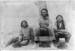 photograph: Three of Uncle Sam's Pets. We get rations every 29 days Three Lakota teenage boys in western clothing, sitting near a tree, probably on or near Pine Ridge Reservation. Grabill, John C. H., photographer. Three of Uncle Sam's Pets. We get